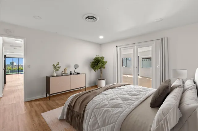 a bedroom with a large bed and wooden floor