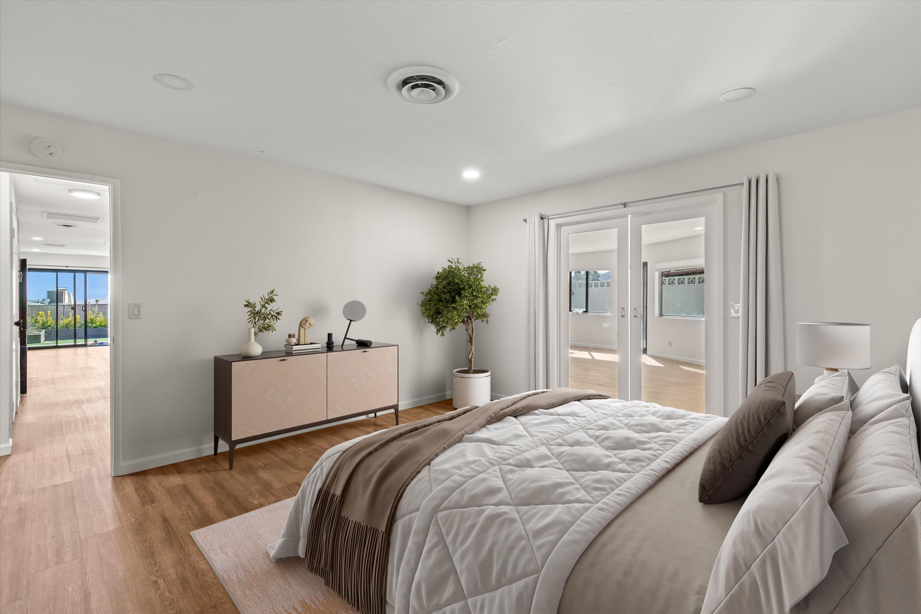 7458 Cardillo Trail Yucca Valley, CA 92284 - Photo 27 of 47 a bedroom with a large bed and wooden floor