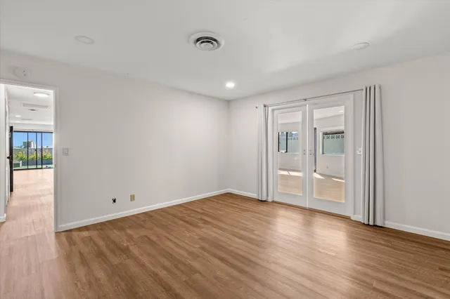 a view of empty room with wooden floor