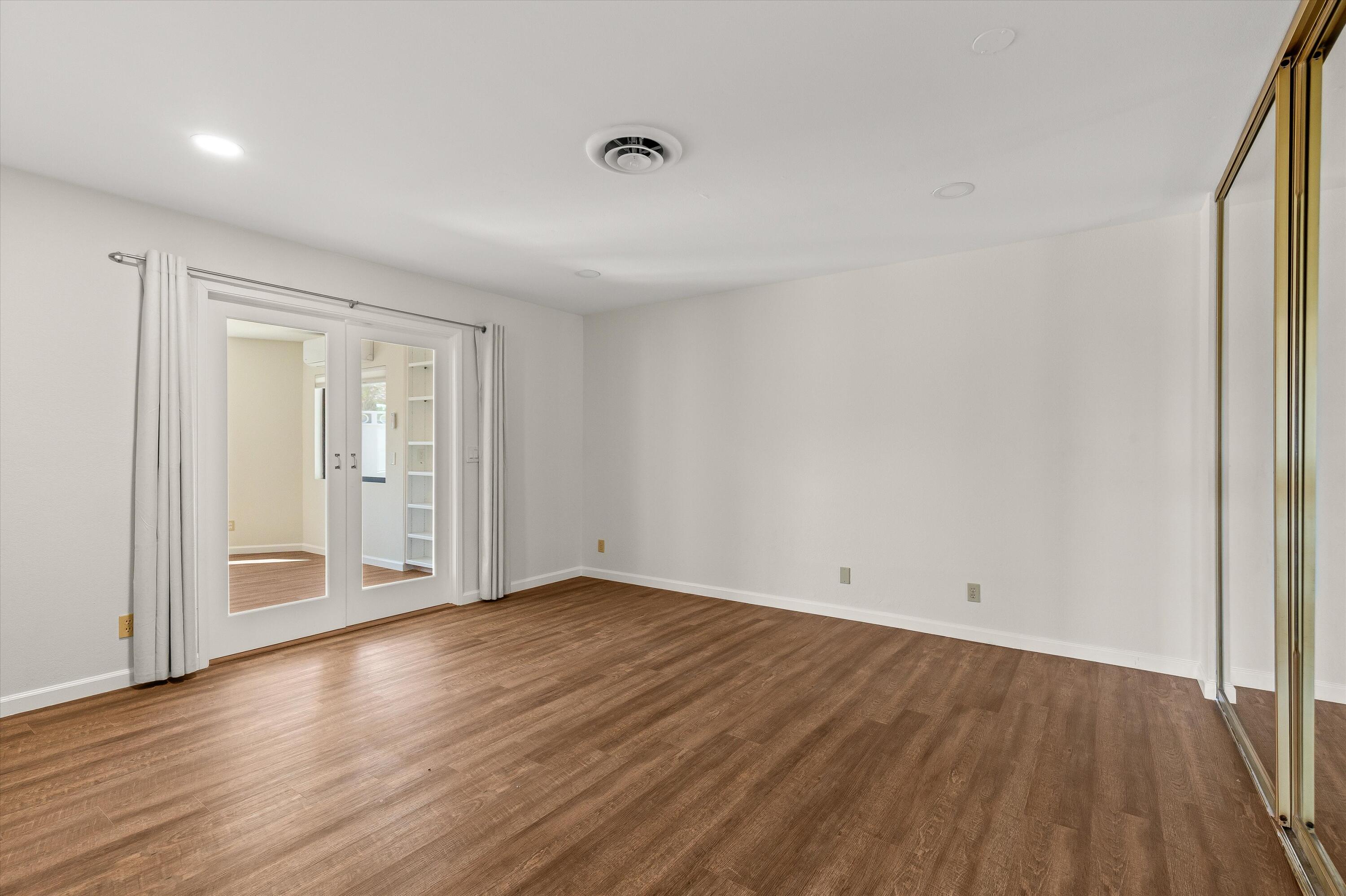7458 Cardillo Trail Yucca Valley, CA 92284 - Photo 29 of 47 a view of an empty room with wooden floor and a window