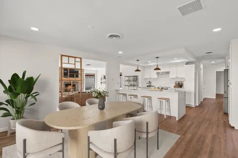 a kitchen with kitchen island granite countertop a sink and white cabinets