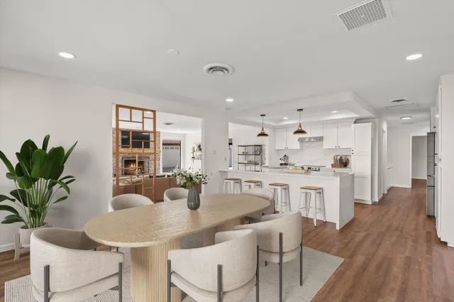 a kitchen with kitchen island granite countertop a sink and white cabinets