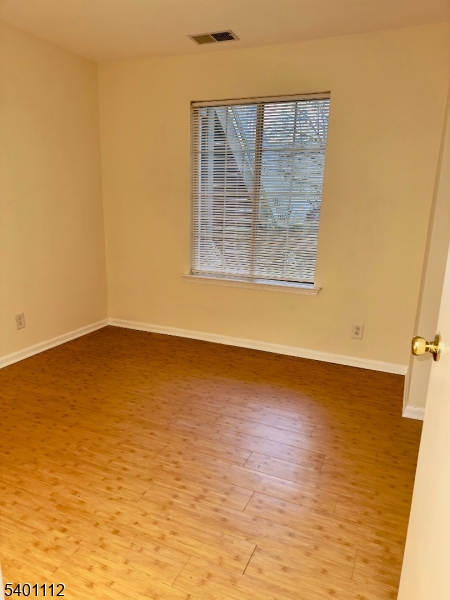 71 Sage Court, Unit 71 Bedminster, NJ 07921 - Photo 8 of 10 a view of an empty room with wooden floor and a window