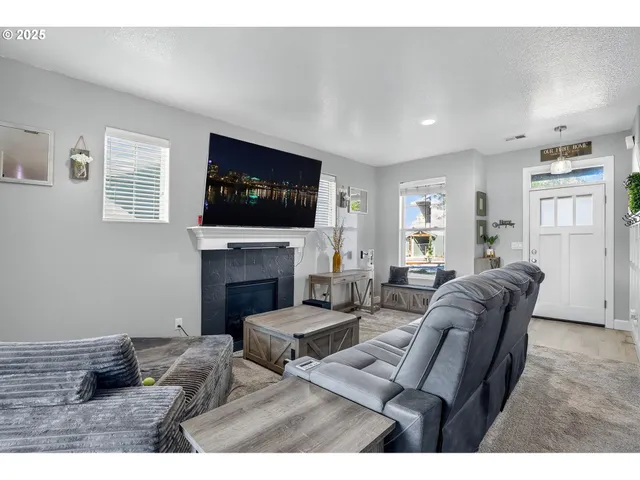 a living room with furniture a flat screen tv and a fireplace