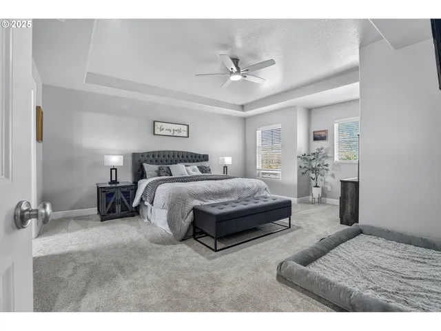 a spacious bedroom with a bed a couch and a ceiling fan