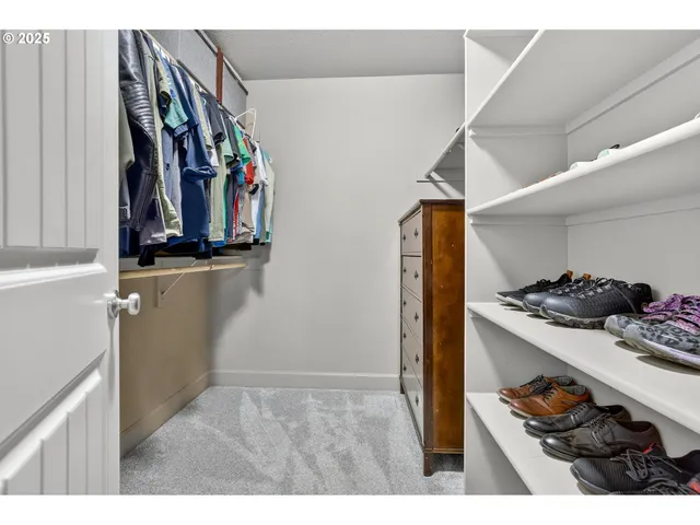 a view of walk in closet with clothes and shoes