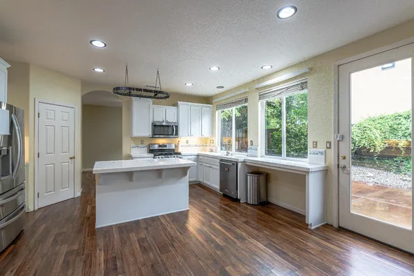 a kitchen with stainless steel appliances granite countertop cabinets wooden floor and a sink