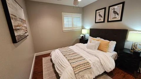 a bedroom with bed and wooden floor