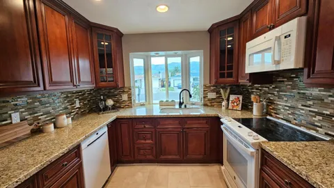 a kitchen with stainless steel appliances granite countertop a sink stove and cabinets