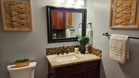 a bathroom with a sink a toilet and mirror