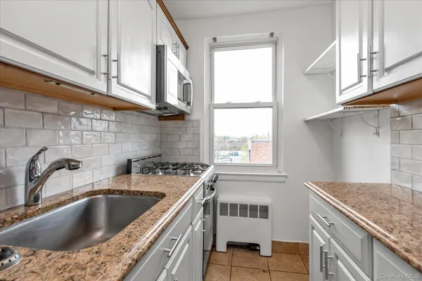 a kitchen with granite countertop a sink and a window