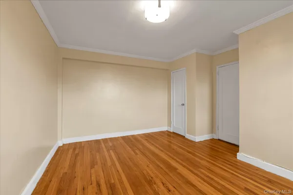 a view of empty room with wooden floor