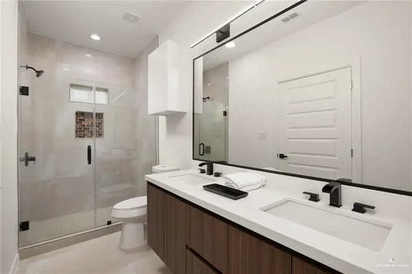 a bathroom with a sink a toilet and shower