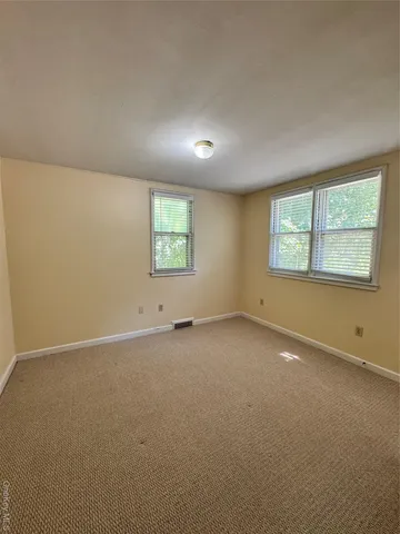 an empty room with closet and windows