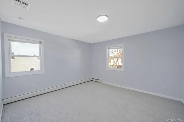 a view of a white house with a big yard and large tree