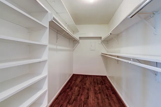 a view of walk in closet with wooden floor