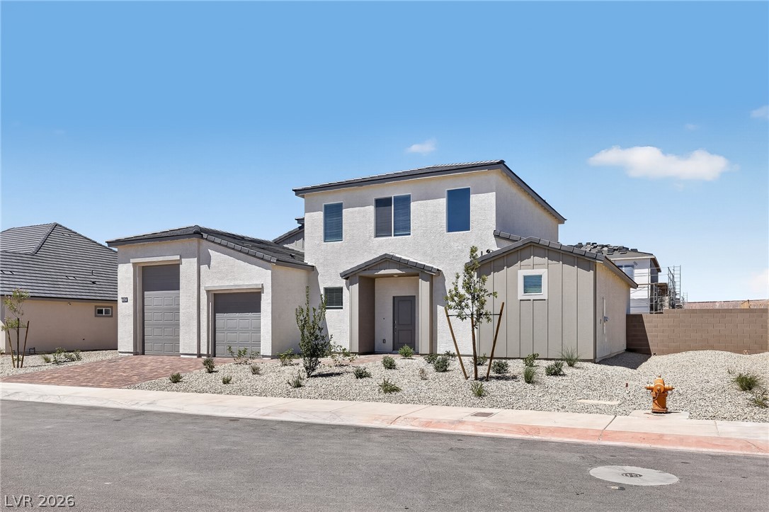 347 Sam Way Mesquite, NV 89027 - Photo 4 of 32 Modern desert home offers two garage bays and a low-maintenance gravel landscape.