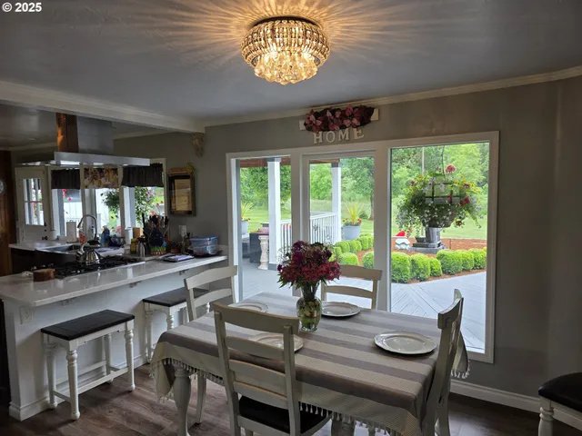 a view of a dining room with furniture a chandelier and wooden floor