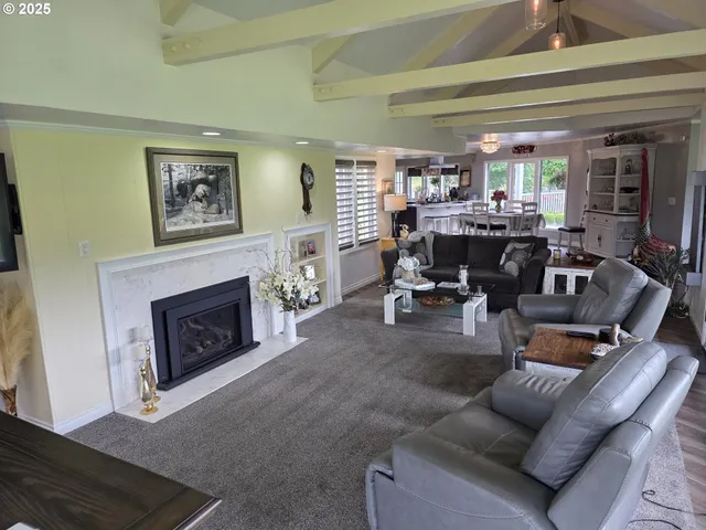 a living room with furniture a fireplace and a large window