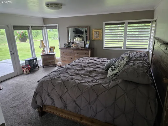a bedroom with a bed and large windows