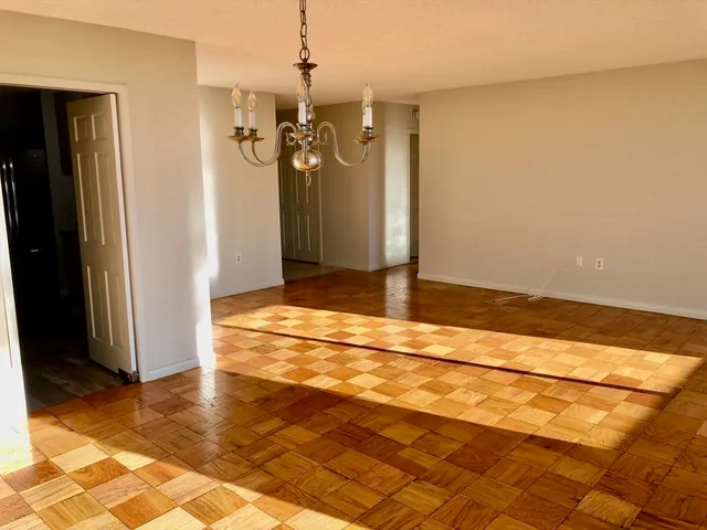 a view of a livingroom with a chandelier and refrigerator
