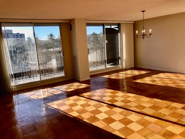 a view of a bedroom with wooden floor and large windows
