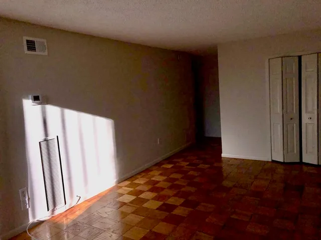 an empty room with wooden floor and a window