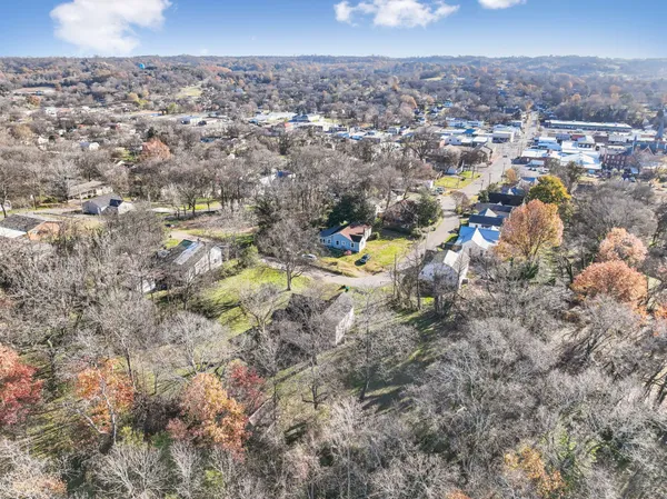 an aerial view of a house with a forest