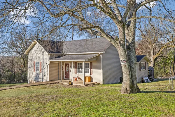 a view of a house with backyard and tree