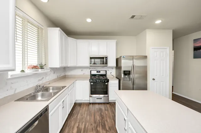 a kitchen with a refrigerator a sink and wooden cabinets