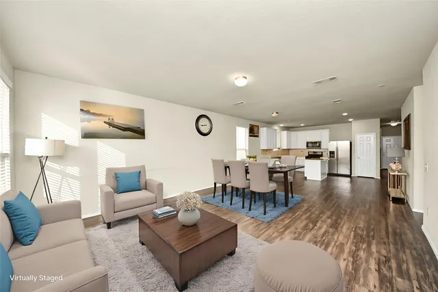 a living room with furniture and view of kitchen