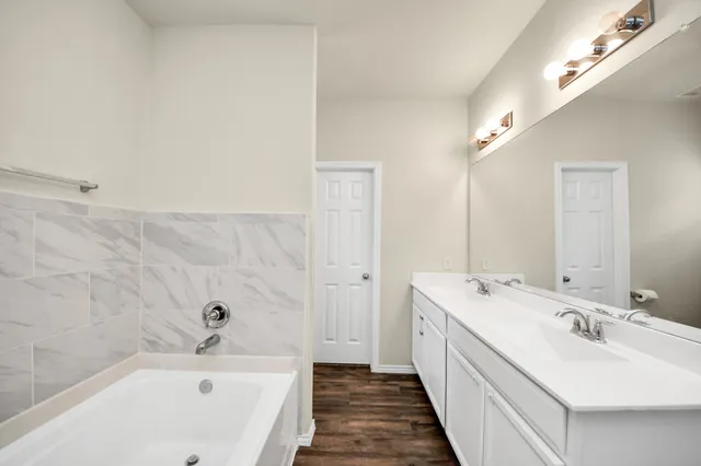 a bathroom with a double vanity sink and mirror with shower