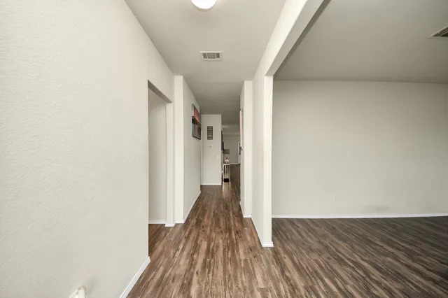 a view of a hallway with wooden floor