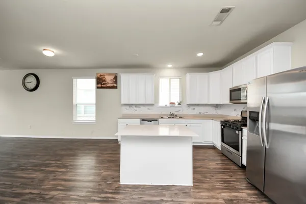 a kitchen with stainless steel appliances granite countertop a sink stove and refrigerator