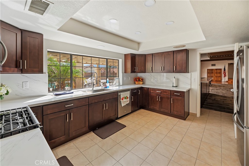 2664 Hazy Way Banning, CA 92220 - Photo 30 of 56 a kitchen with stainless steel appliances granite countertop a stove sink and cabinets