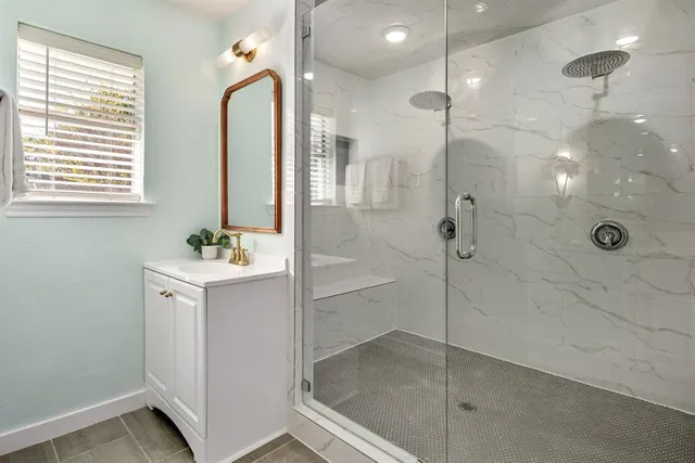 a bathroom with a shower sink and mirror