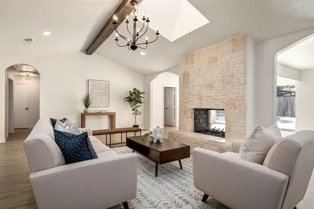 a living room with furniture a fireplace and a chandelier