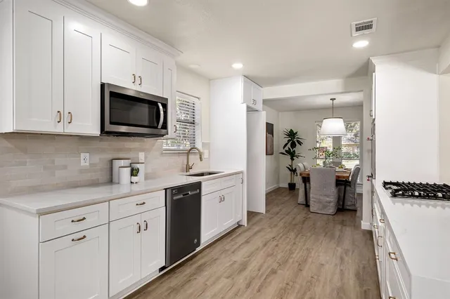 a kitchen with a sink stove and cabinets