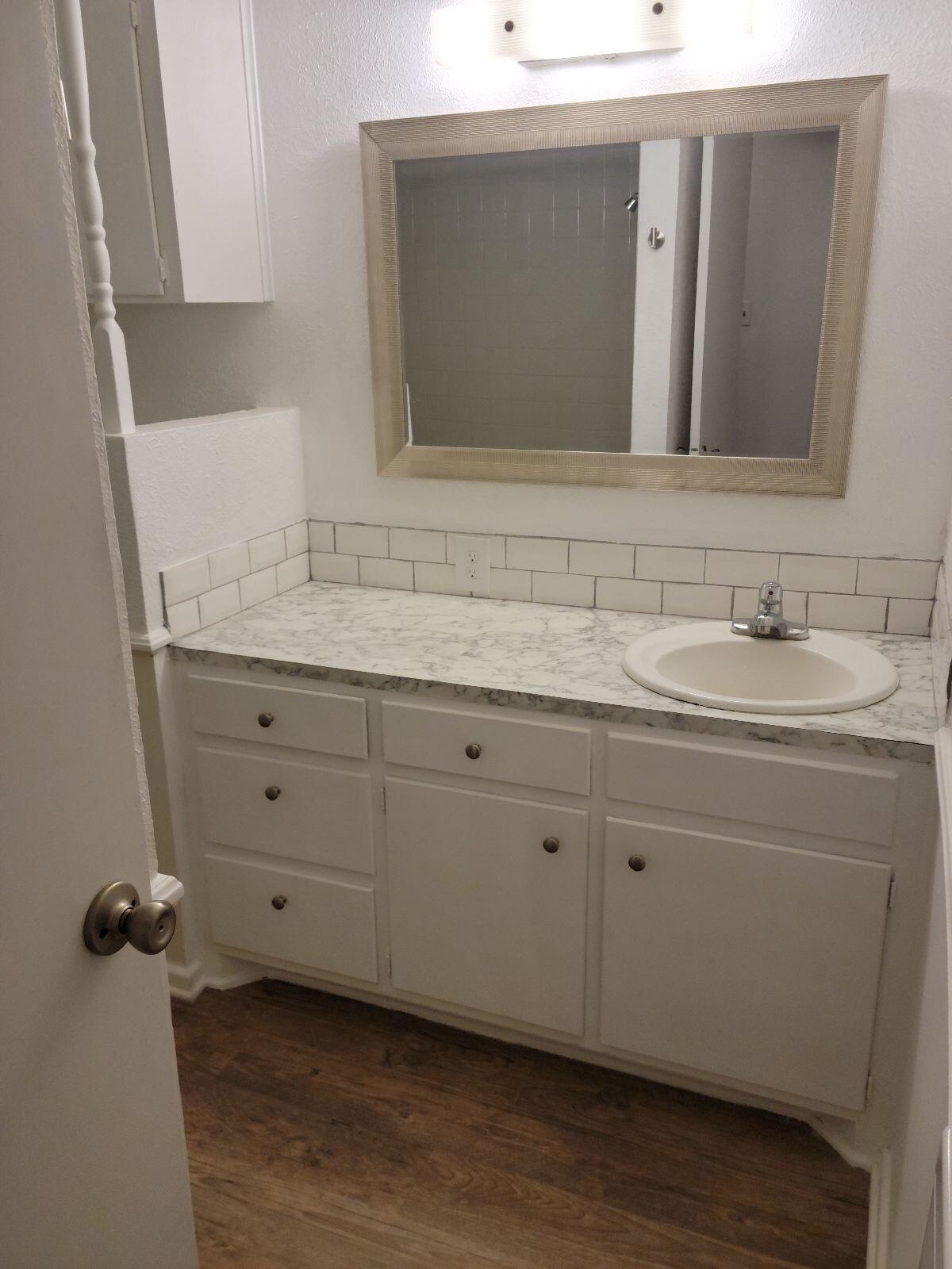 4412 29th Street Lubbock, TX 79410 - Photo 4 of 7 a bathroom with a double vanity sink and mirror
