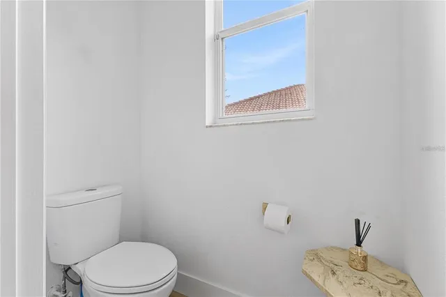 a spacious bedroom with a bed a couch and a potted plant on the dresser