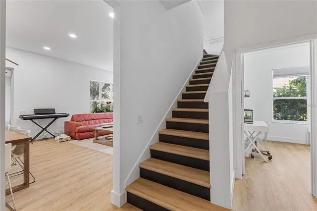 a view of swimming pool with a lawn chairs and palm tree