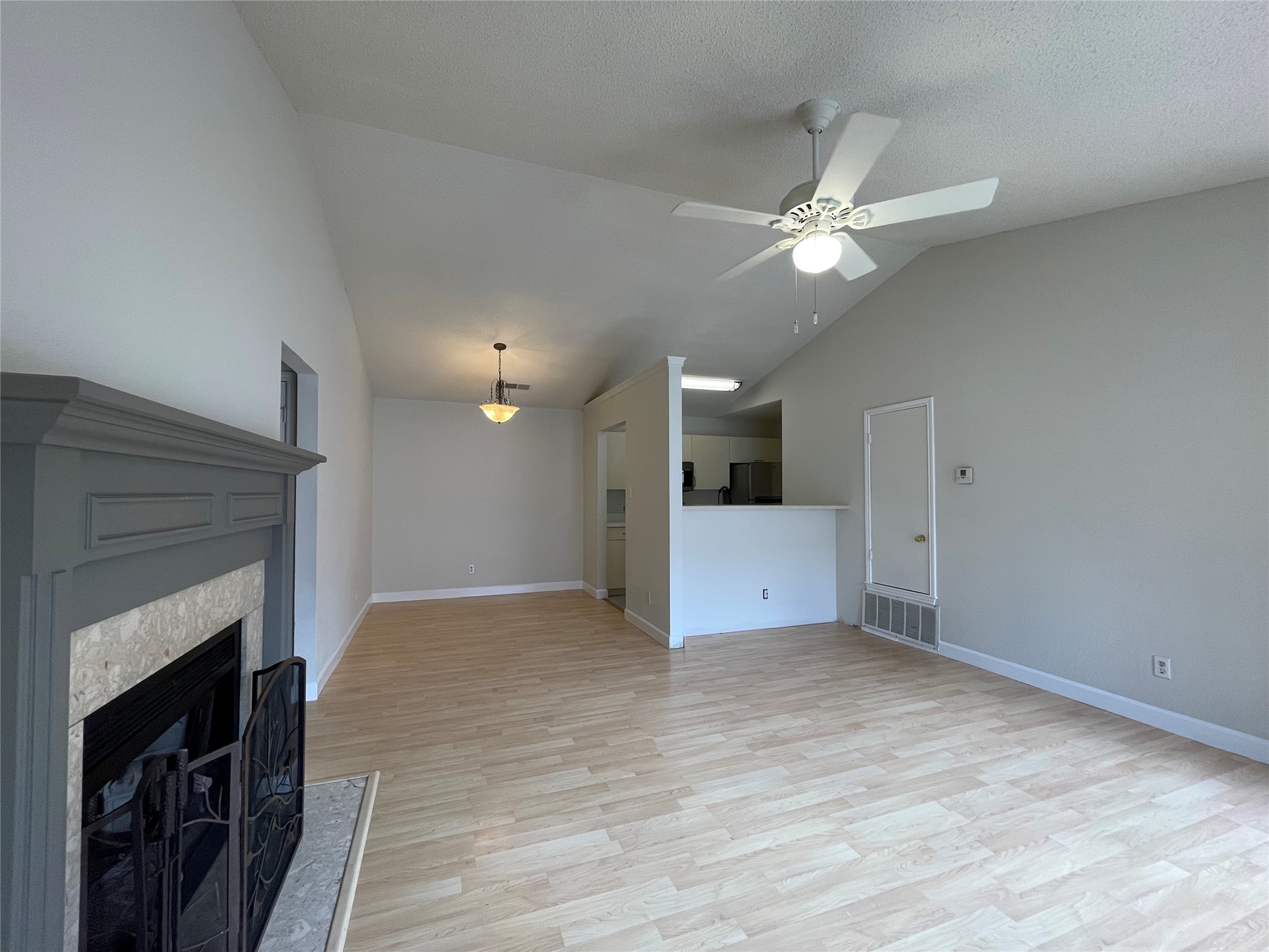 2031 Redwing Way Round Rock, TX 78664 - Photo 6 of 25 A welcoming living room featuring a cozy fireplace and Laminate floors with an open transition to the kitchen.