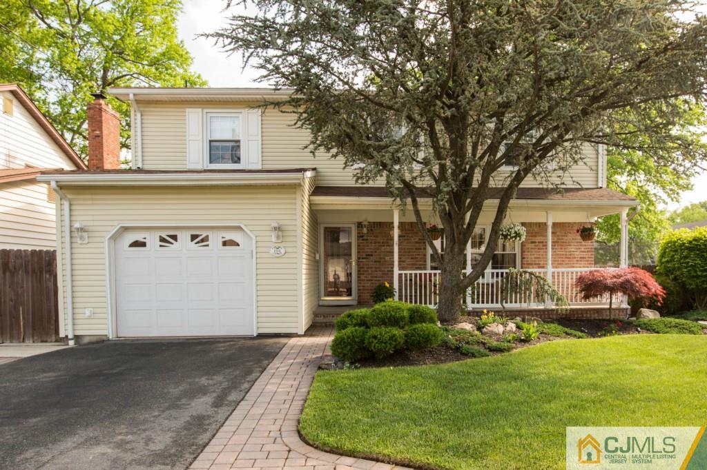 104 South Cliff Road Colonia, NJ 07067 - Photo 1 of 25 a front view of a house with a yard and garage