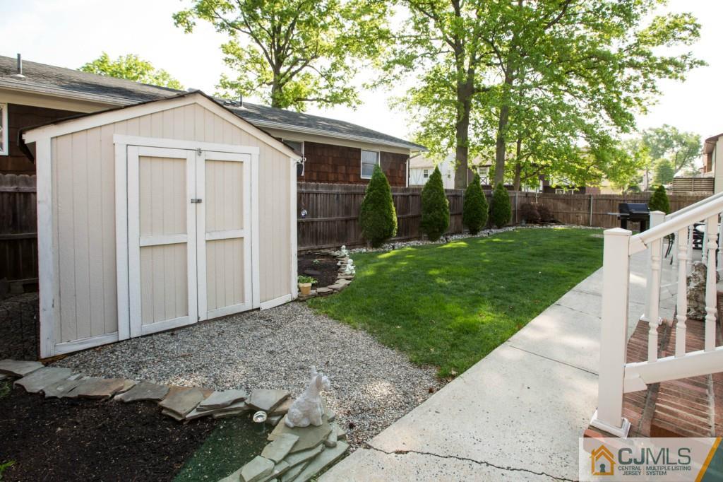 104 South Cliff Road Colonia, NJ 07067 - Photo 22 of 25 a view of a white house with a small yard and large tree