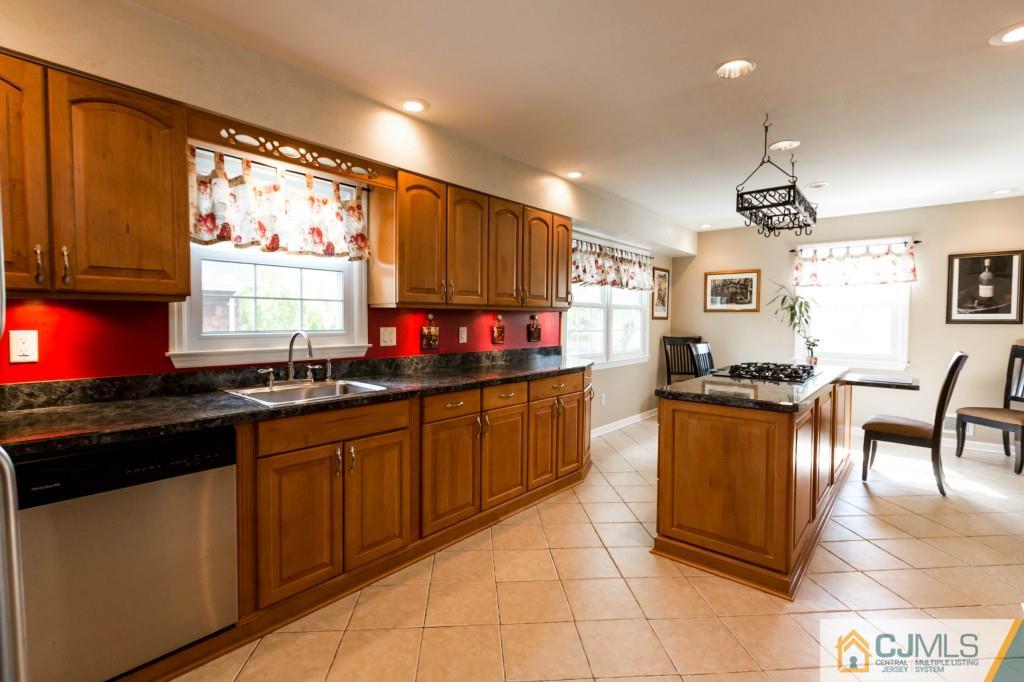 104 South Cliff Road Colonia, NJ 07067 - Photo 7 of 25 a kitchen with granite countertop a stove a sink dishwasher and a microwave