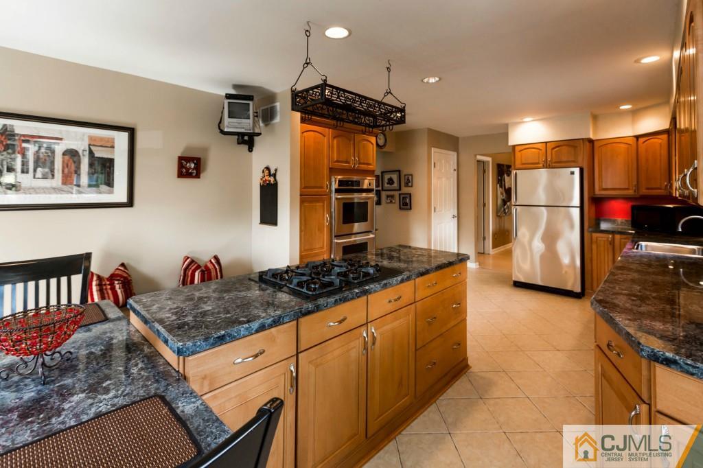 104 South Cliff Road Colonia, NJ 07067 - Photo 9 of 25 a kitchen with stainless steel appliances granite countertop a stove and a refrigerator