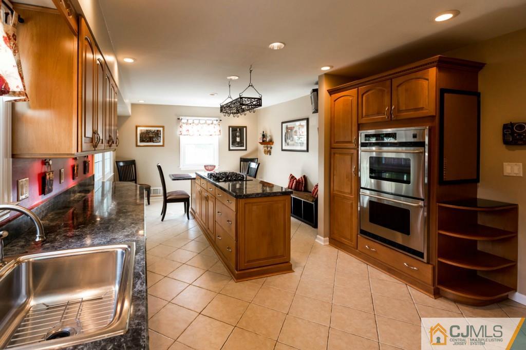 104 South Cliff Road Colonia, NJ 07067 - Photo 10 of 25 a kitchen with stainless steel appliances a stove a sink and a microwave