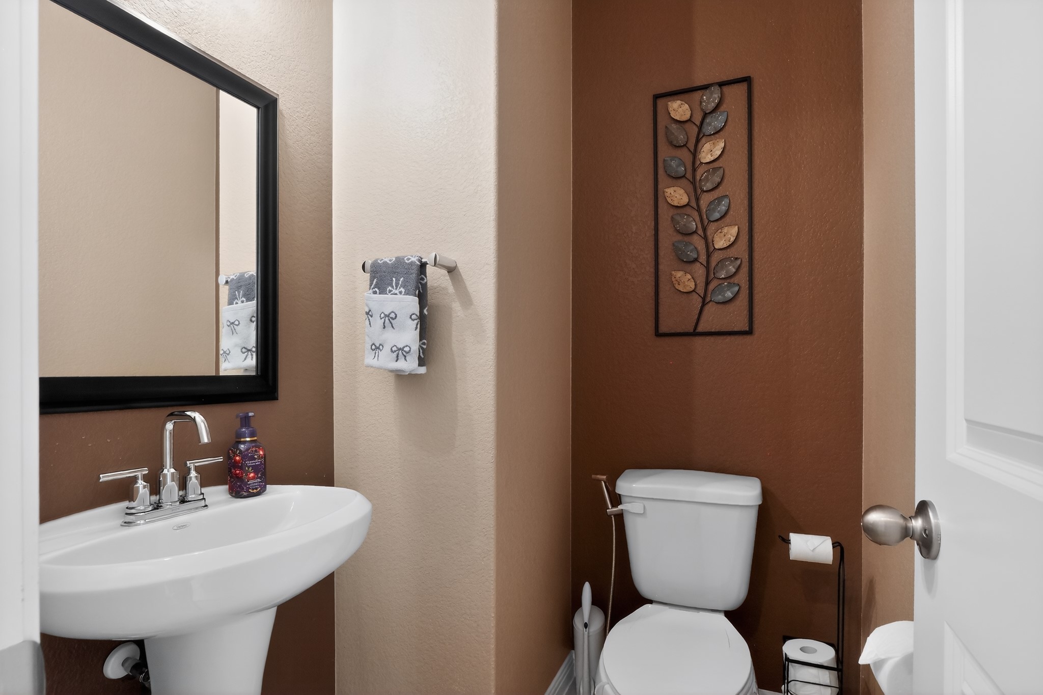 114 Bosco Road Hutto, TX 78634 - Photo 16 of 39 A compact and functional bathroom features a modern pedestal sink and a clean, traditional toilet.