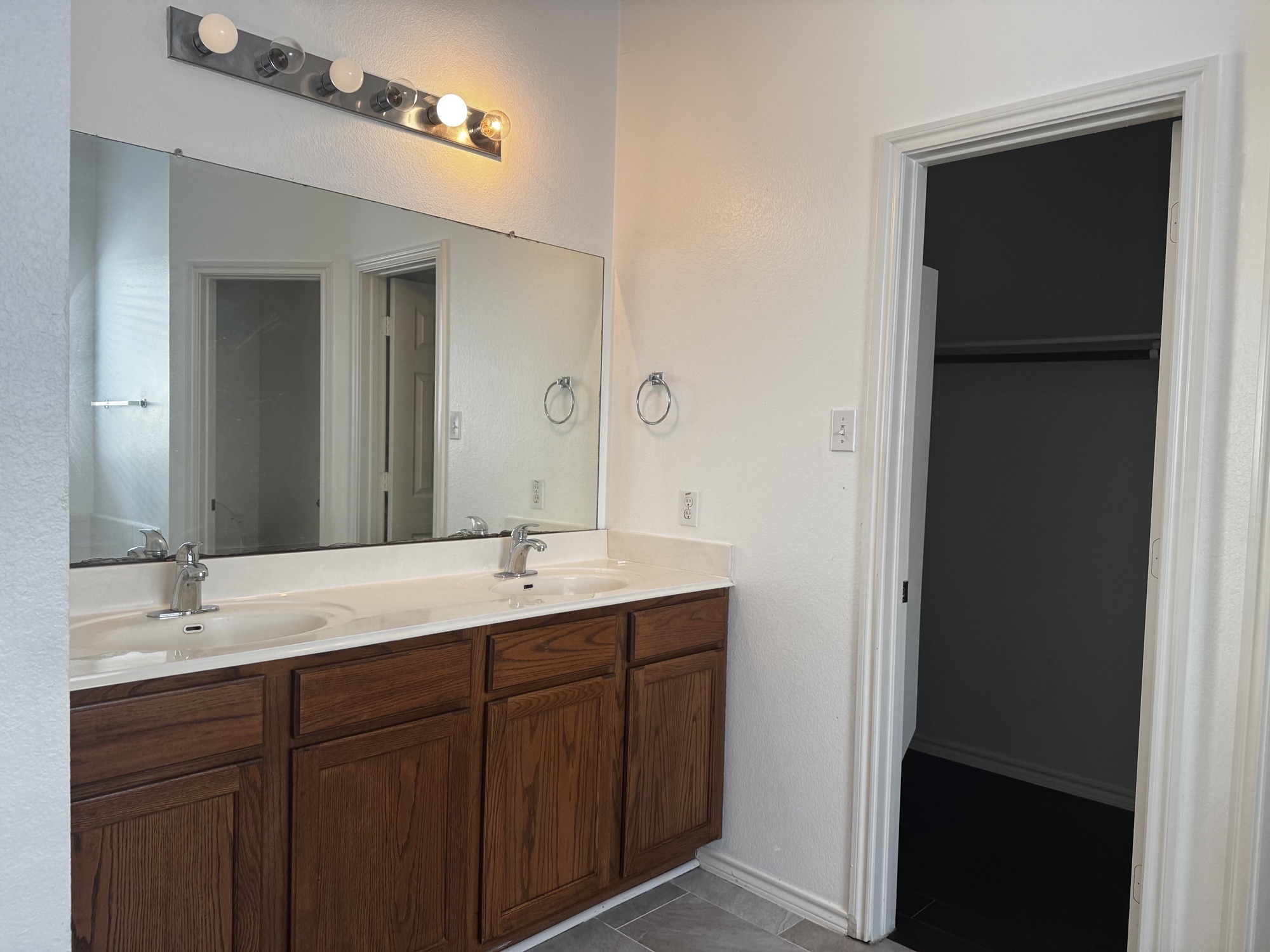 304 Valona Loop Round Rock, TX 78681 - Photo 12 of 15 Dual vanity with wood-finish cabinetry, light-toned countertop, and undermount sinks