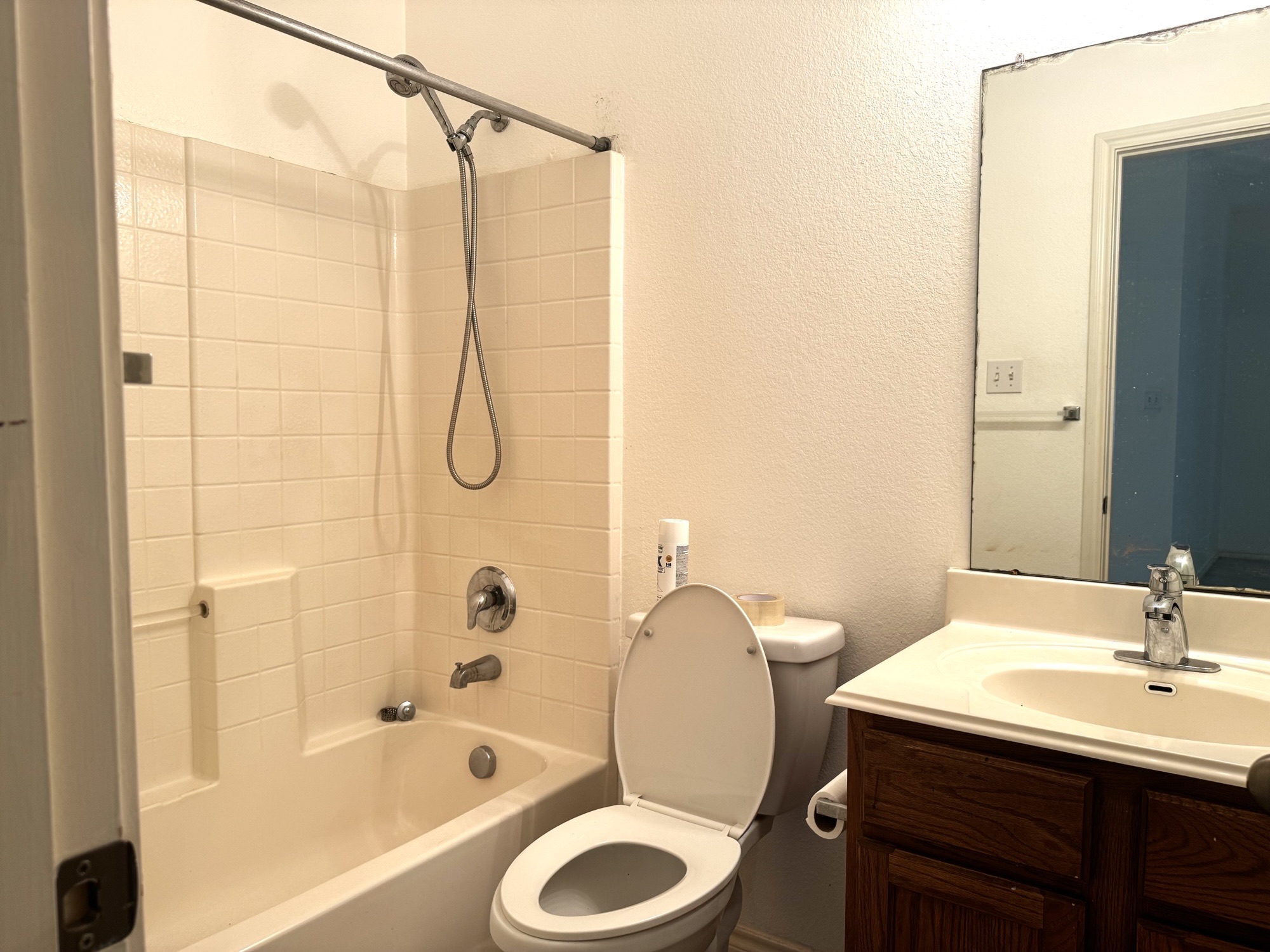 304 Valona Loop Round Rock, TX 78681 - Photo 6 of 15 Bathroom featuring a built-in tub and shower combination with ceramic tile surround, a wood-finish vanity with an integrated sink, and a wall-mounted mirror